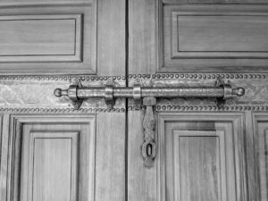 Close-up of an intricately carved wooden door with an ornate metal bolt in Morocco.